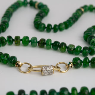 Green beaded necklace with a gold clasp on a white background