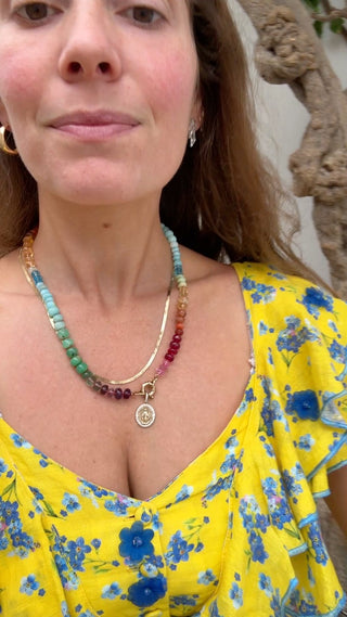 Female founder wearing a colorful beaded necklace and yellow floral dress.