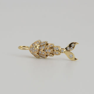 Gold mermaid-shaped pendant with diamond accents on a light gray background