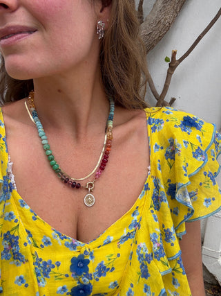 Sorsa Jewellery founder wearing a yellow floral dress with a colorful beaded necklace.