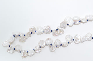 Pearl necklace with blue accents on a white background