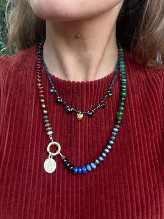 sorsa jewellery founder wearing a colorful beaded necklace with a red sweater