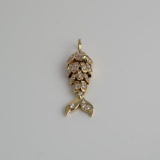 Gold mermaid tail pendant with diamond accents on a gray background