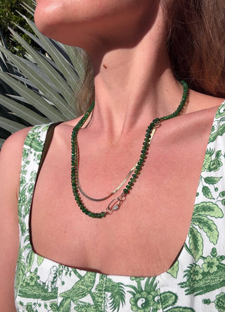 sorsa jewelelry founder wearing a green beaded necklace with a patterned top outdoors