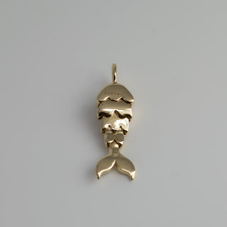 Gold mermaid tail pendant on a gray background