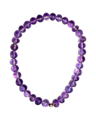 Amethyst stretch bracelet with a 14k gold bead, waterproof everyday design.