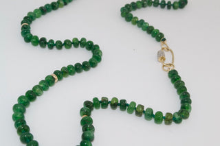 Green beaded necklace with a gold clasp on a white background