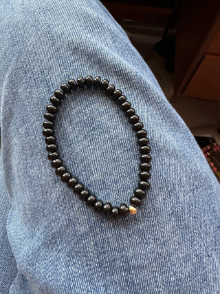 Onyx stretch bracelet with black onyx beads and a 14k gold bead.