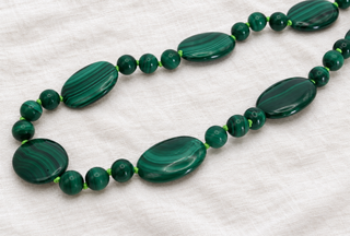 Side view of the Ravello Malachite Necklace, graduated malachite beads with a 9k gold bolt ring clasp.
