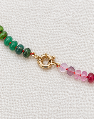 Close-up of the River Cafe Rainbow Gemstone Necklace, hot pink and blue gemstones hand-knotted on silk with 9k gold.