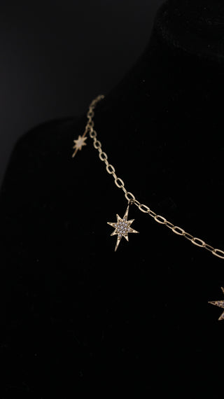 Star Dust Necklace close-up, diamond-set starburst pendant on a rollo link 9k gold chain.