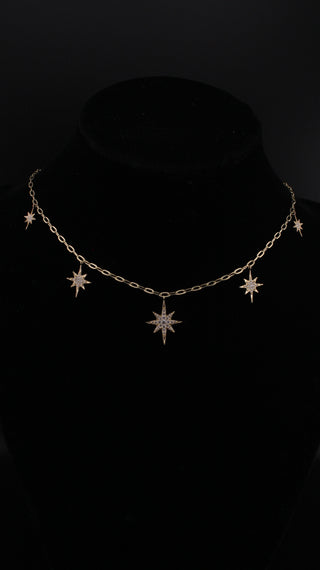 Star Dust Necklace by Sorsa Jewellery, five diamond-set starbursts on a rollo link 9k gold chain.