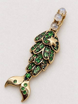 Front view of the Tsavorite Mermaid Tail Charm by Sorsa Jewellery, green tsavorite scales in blackened 9k gold with a moonstone bail.