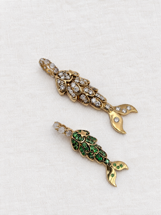 Petite and large mermaid tail charms side by side, tsavorite in blackened 9k gold, by Sorsa Jewellery.