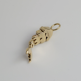 Gold mermaid shaped pendant on a light gray background